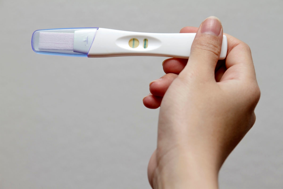 Holding positive pregnancy test.