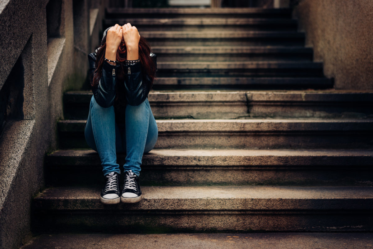 Depressed teenager sitting lonely