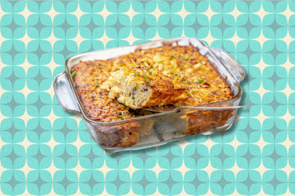 A photo of kugel in a glass casserole dish in front of a vintage kitchen inspired background