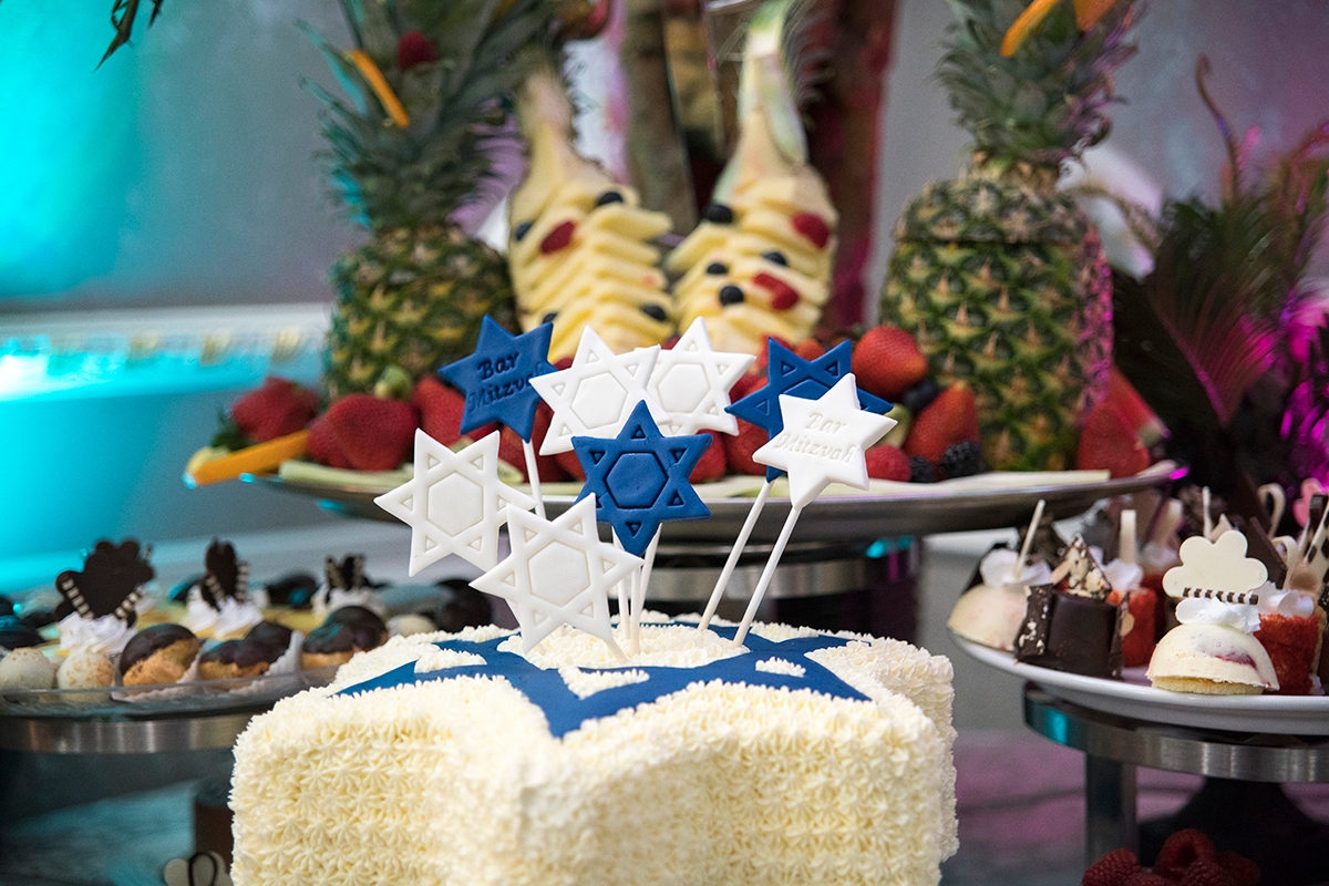 Restaurant banquet room decorated for Bar Mitzvah. Brooklyn, New York City, USA. Sweets and fruits decorated on the plate.