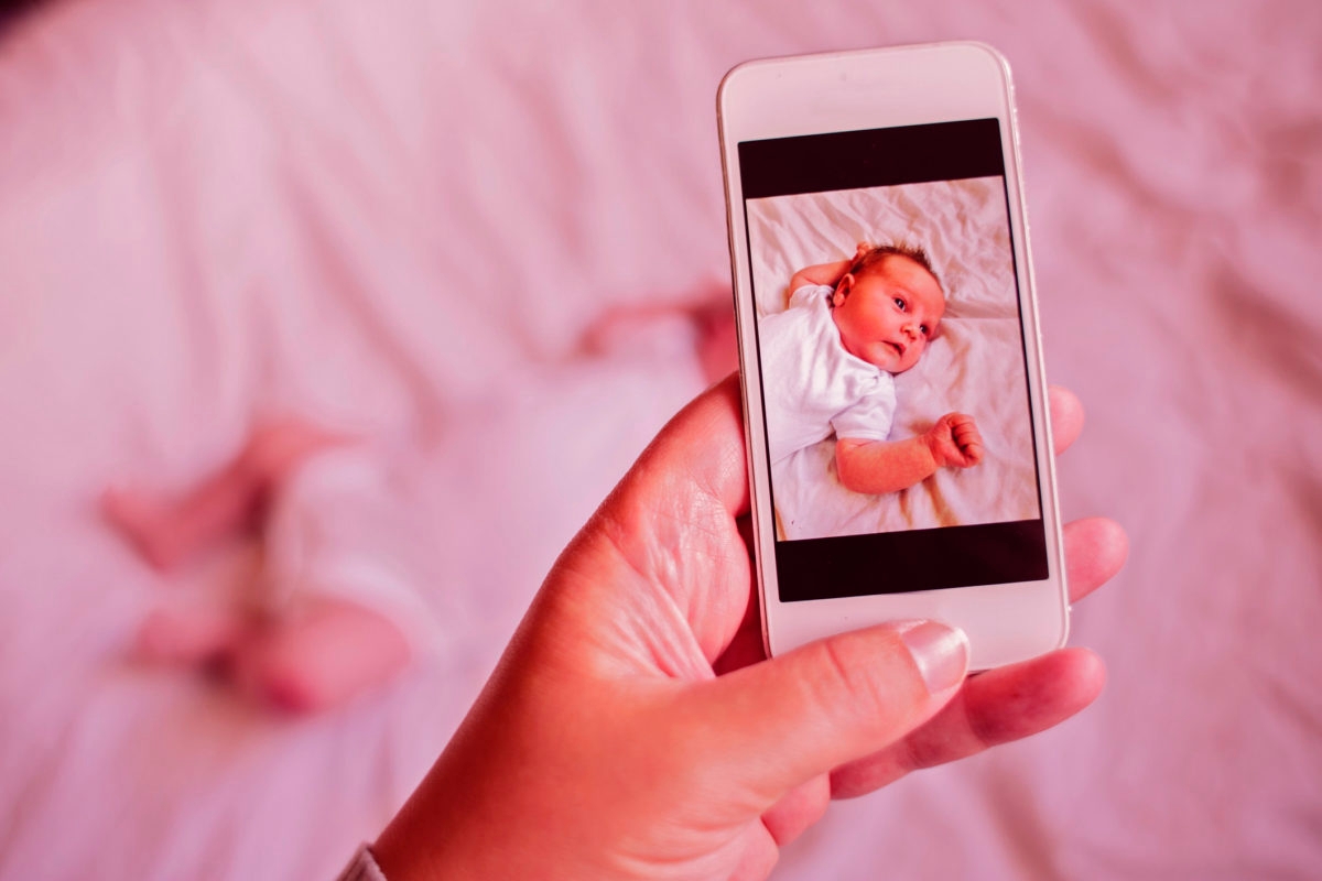 Mother taking a smartphone picture of her baby