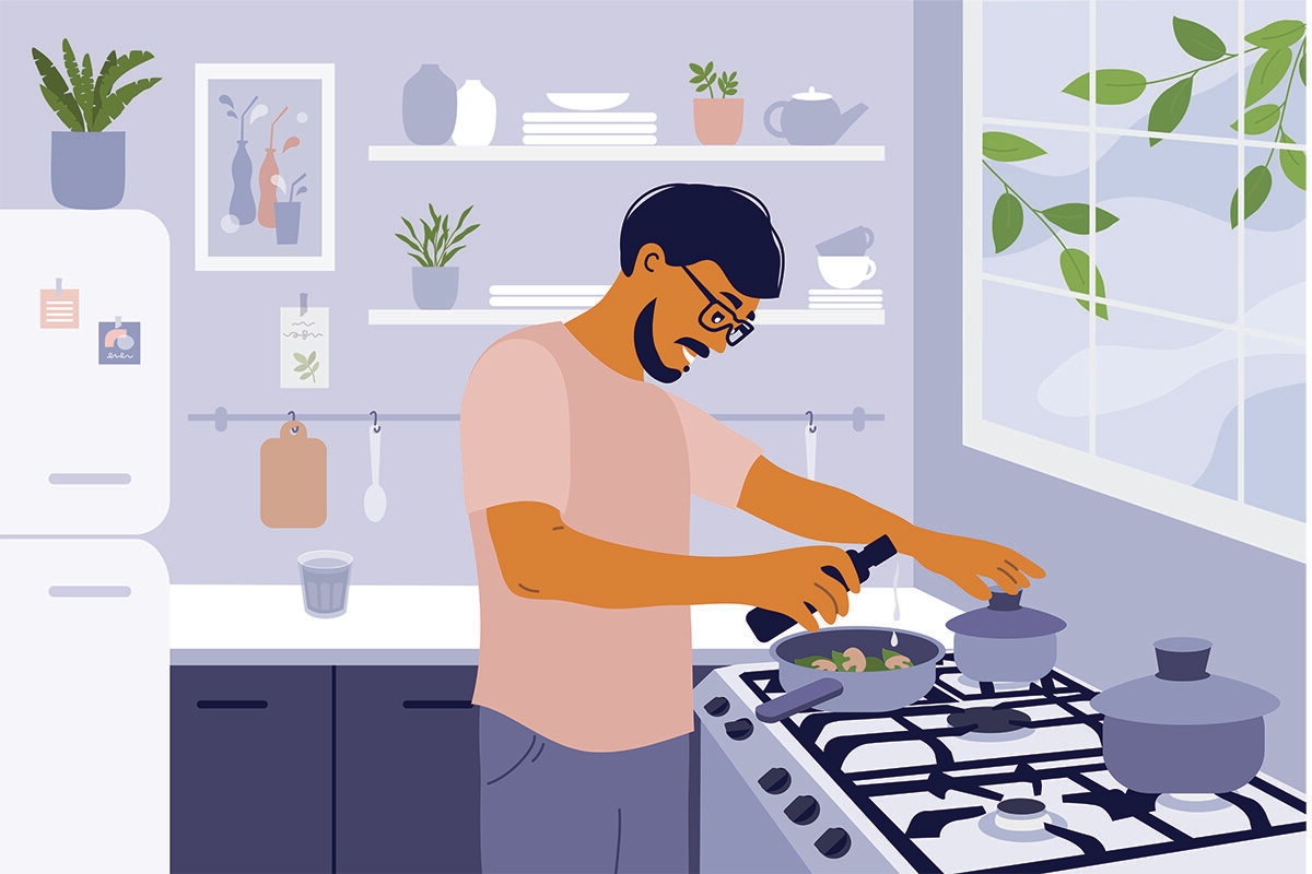 Smiling man cooking healthy meals in small cozy kitchen