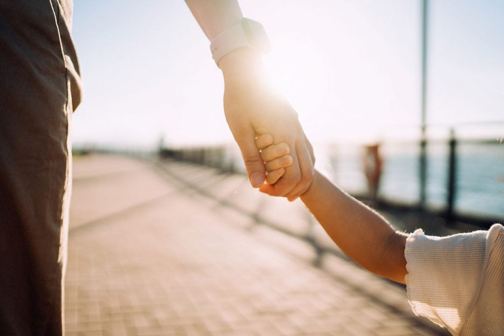 Parent and child holding hands.