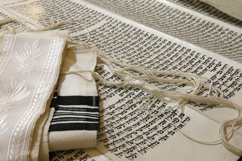 A Torah scroll and Jewish prayer shawl.