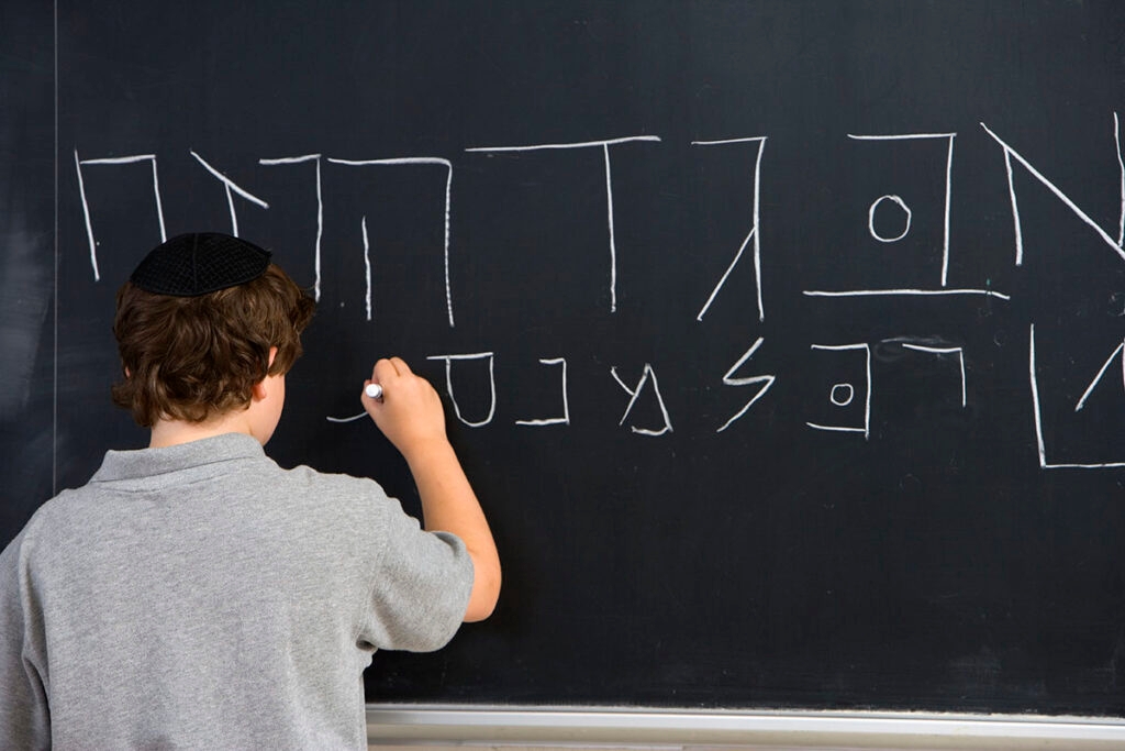 A young student learning to write in Hebrew.