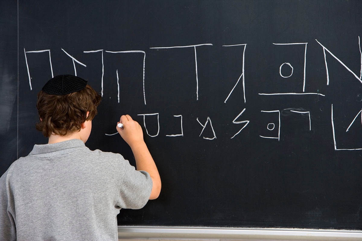 A young student learning to write in Hebrew.