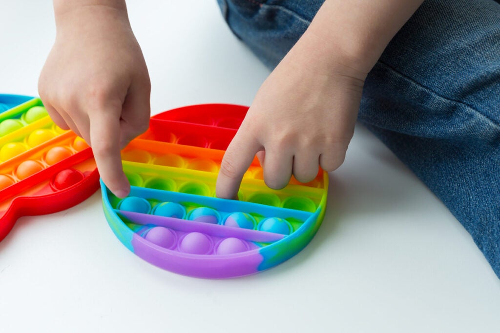 Kid playing with push pop fidget toy