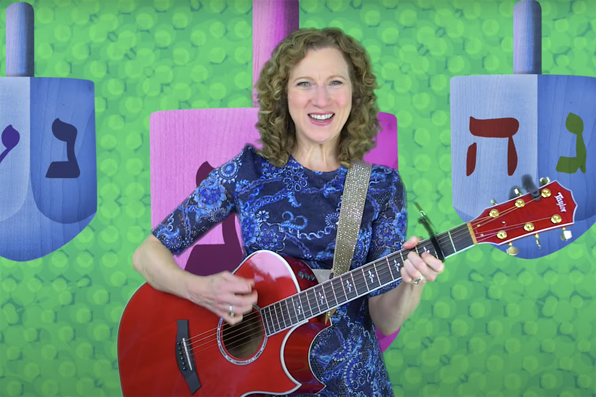 Laurie Berkner on a background of dreidels