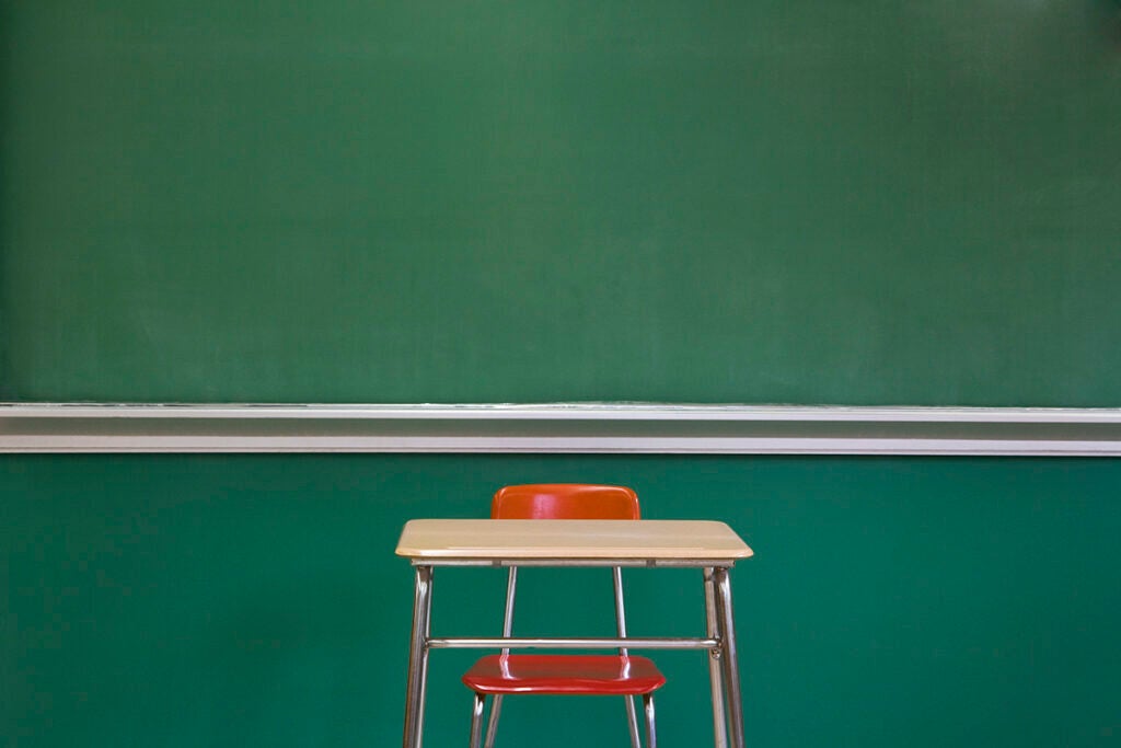 Empty Desk by Classroom Chalkboard