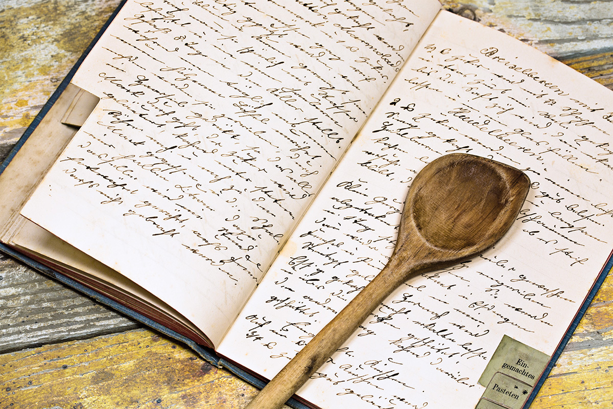 old recipe book with wooden spoon