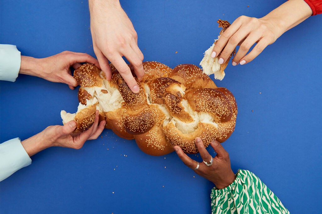 hands ripping at a challah