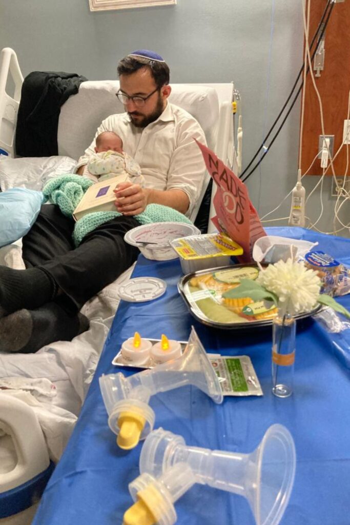 Mila held by her father in the hospital