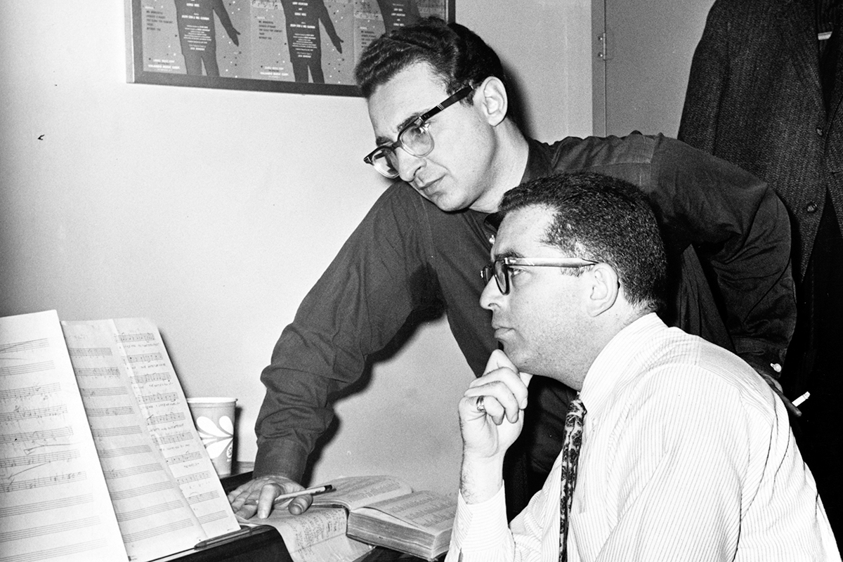 View of American musical theater composer Jerry Bock (1928 - 2010) (seated) and lyricist Sheldon Harnick as they look over a musical score at a piano, New York, New York, 1960. (Photo by Walter Albertin/New York World-Telegram & Sun/PhotoQuest/Getty Images)