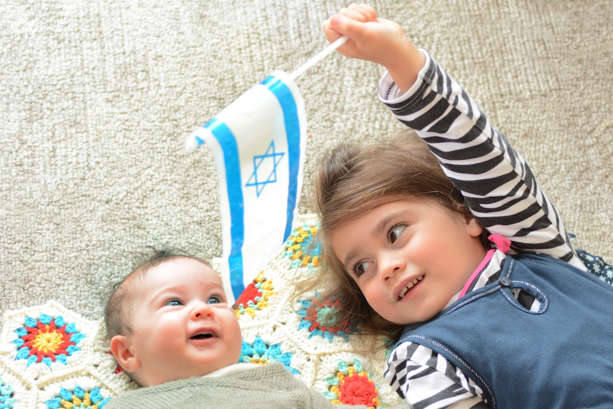 Two Israeli sisters holding the Israeli flag.