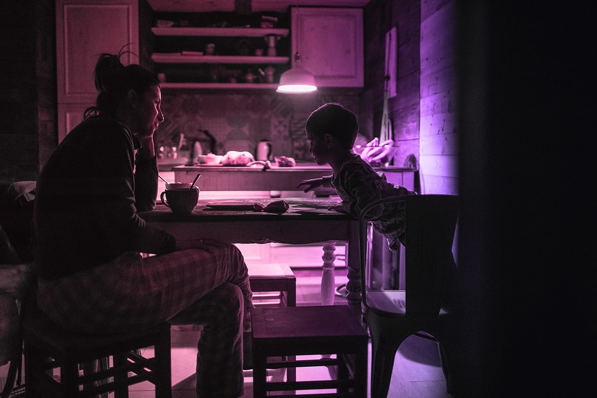 Photo of young mother spending precious time with her son in kitchen, right before sleep