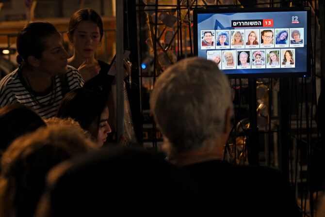 TEL AVIV, ISRAEL - NOVEMBER 24: People watch the news broadcasts as hostages are released into Egypt before being brought into Israel by the ICRC, outside the Museum of Tel Aviv on November 24, 2023 in Tel Aviv, Israel. A four-day ceasefire began between Israel and Hamas began this morning, although Israeli forces remain in Gaza. A total of 50 hostages currently held by Hamas are to be released during the temporary truce, the first such pause in fighting since Oct. 7, when Hamas launched its surprise attack and Israeli responded with a vast military offensive to destroy the militant group that governs Gaza. Under the deal, 150 Palestinian prisoners are also to be released from Israel, and more humanitarian aid will be admitted at the Gaza-Egypt border crossing.