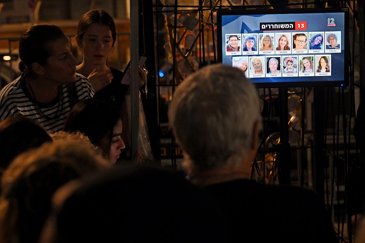 TEL AVIV, ISRAEL - NOVEMBER 24: People watch the news broadcasts as hostages are released into Egypt before being brought into Israel by the ICRC, outside the Museum of Tel Aviv on November 24, 2023 in Tel Aviv, Israel. A four-day ceasefire began between Israel and Hamas began this morning, although Israeli forces remain in Gaza. A total of 50 hostages currently held by Hamas are to be released during the temporary truce, the first such pause in fighting since Oct. 7, when Hamas launched its surprise attack and Israeli responded with a vast military offensive to destroy the militant group that governs Gaza. Under the deal, 150 Palestinian prisoners are also to be released from Israel, and more humanitarian aid will be admitted at the Gaza-Egypt border crossing.