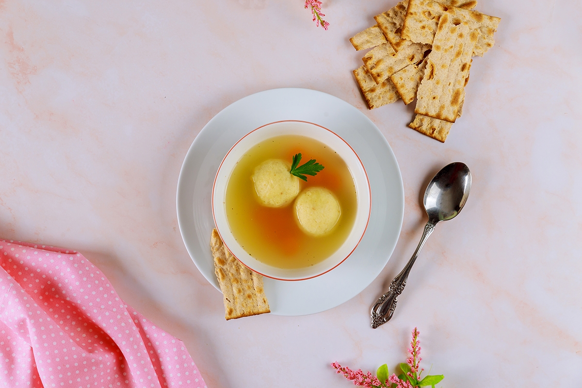 Chicken broth with matzo balls and matzos bread.