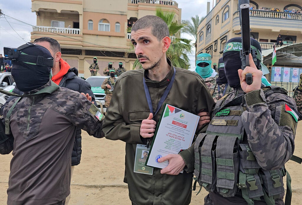 DEIR AL BALAH, GAZA - FEBRUARY 8: Al-Qassam Brigades, the armed wing of Hamas, hand over Israeli hostages Or Levy, Eliyahu Sharabi, and Ohad Ben Ami to the International Committee of the Red Cross on Saturday as part of the ongoing hostage swap in Deir al Balah, Gaza, on February 8, 2025.