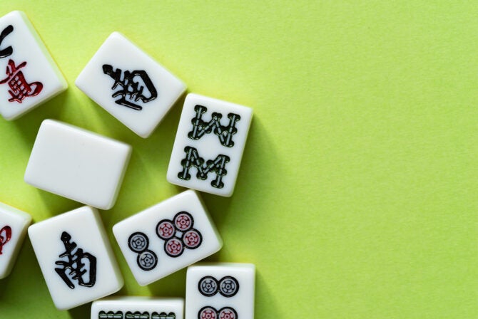 Mahjong tiles lined up on a green background