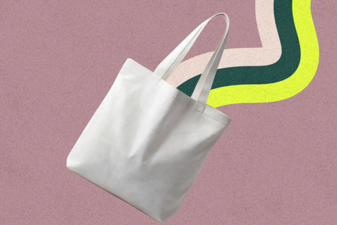 A tan canvas tote bag floating on a rainbow background.