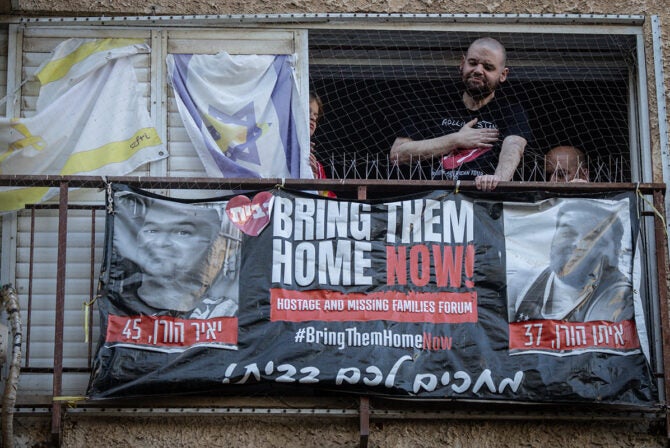 KFAR SABA, ISRAEL - OCTOBER 16: Former hostage Eitan Horn (L) reacts next to his brother Amos Horn on his balcony as he is welcomed home on October 16, 2025 in Kfar Saba, Israel. Horn was released from captivity in Gaza on Oct. 13th as part of the ceasefire agreement between Israel and Hamas. Horn was taken captive from Nir Oz during the attacks of Oct. 7, 2023.