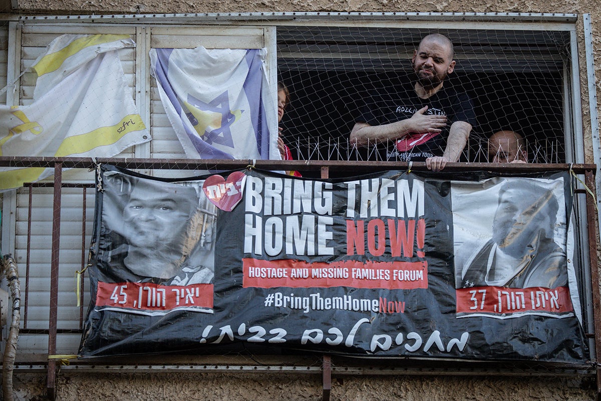 KFAR SABA, ISRAEL - OCTOBER 16: Former hostage Eitan Horn (L) reacts next to his brother Amos Horn on his balcony as he is welcomed home on October 16, 2025 in Kfar Saba, Israel. Horn was released from captivity in Gaza on Oct. 13th as part of the ceasefire agreement between Israel and Hamas. Horn was taken captive from Nir Oz during the attacks of Oct. 7, 2023.